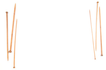 Variety of wooden knitting needles frame on white background