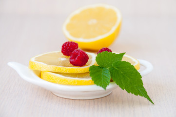 Lemon slices, berries and raspberry leaves on the table