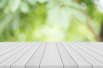 Empty white wood table top on nature green blurred background,space for montage show products