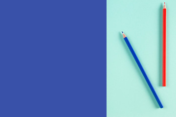 Red and blue colored pencils on blue color background