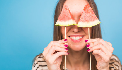 Summer, vacation, diet and vegans concept - Beautiful smiling young woman holding watermelon slice on stick