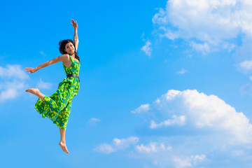 Beautiful woman in bright green dress flies and hovers on the sky. Girl  jumping and feels from prejudice. Beauty and dynamics in flight. Concept of faith in oneself and freedom