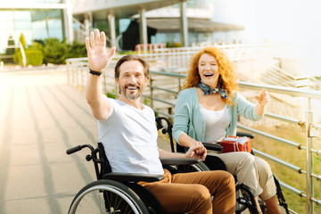 Fototapeta na wymiar Positive wheelchaired man welcoming you