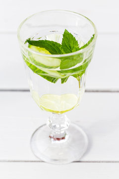 h&auml;lsosam detox vatten i vinglas med mynta, citron och gurka p&aring; vit bakgrund