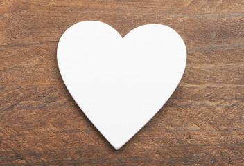 Top view of a white heart on wooden background. Isolated.