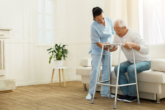 Delighted positive caregiver helping her patient