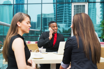 Group of young successful people have met in a cafe.