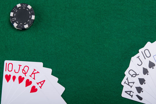 Cards on a green poker table from two poker players