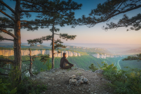 Human sitting in yoga pose on a cliff edge