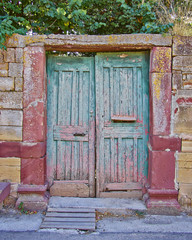 pale green door on vintage house stone wall facade