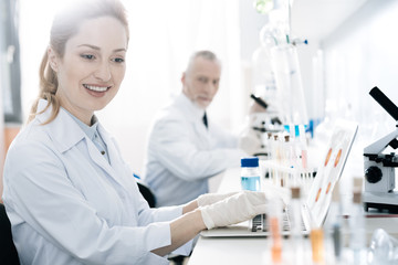 Positive delighted blonde looking at set with test tubes