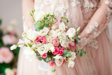 Pregnant girl in a beige dress with a bouquet in hands. Natural. Waiting for a miracle.