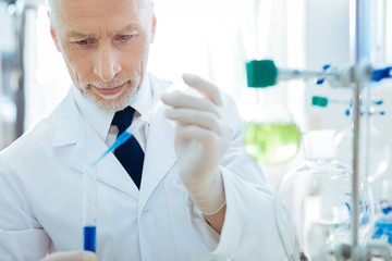 Fototapeta premium Serious bearded male person looking at test tube