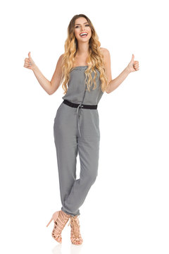 Talking Young Woman In Jumpsuit Is Showing Thumbs Up