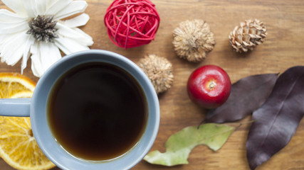 Coffee, fruit and flowers on a wooden table. The concept of the autumn morning.
