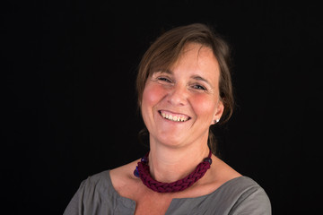 portrait of candid attractive mid-aged caucasian female adult - studio shot in front of dark background