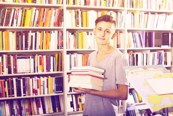 Teenager holding pile of books