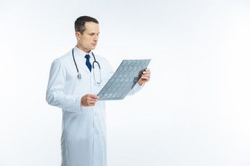Focused practitioner looking at mri image of patient body