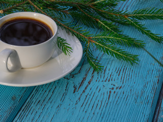 Winter composition. Cup of coffee, pine  branches on wooden table. Copy space. Holiday Christmas concept