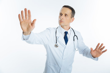 Male physician with stethoscope touching invisible screen