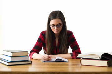 Attractive caucasian girl studying for her exams at home, education concept on white background
