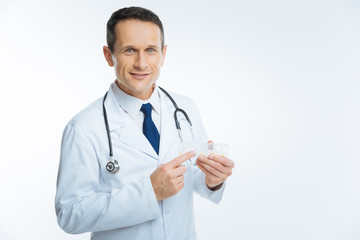 Cheerful male practitioner holding box with pills