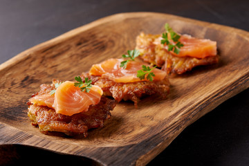 hash browns and salmon on wooden plate