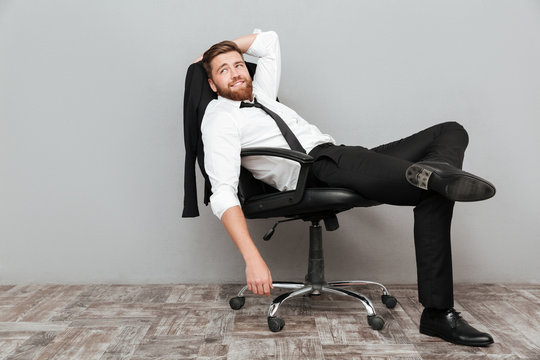 Smiling relaxed businessman resting in office chair