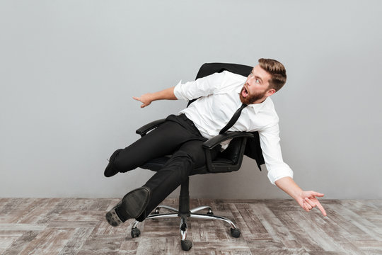 Funny crazy businessman having fun while sitting in office chair
