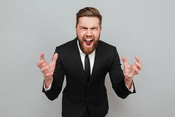 Portrait of an angry bearded man in suit shouting