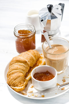 croissants with jam and coffee with milk for breakfast on white table