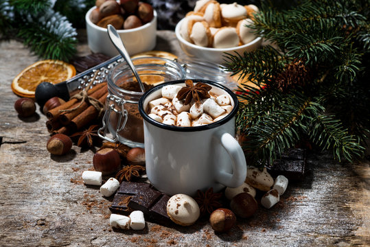 cup of hot chocolate with marshmallows and sweets on wooden table