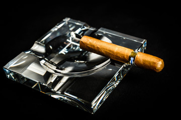 Zigarre im Aschenbecher rauchen
