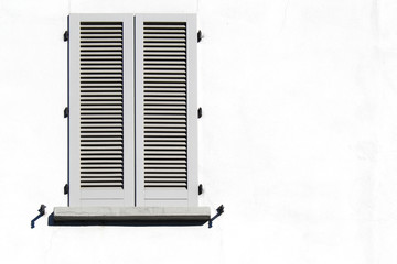 Closed shutter window on a white wall