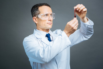 Confident medical professional examining blood sample