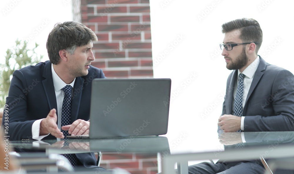 Poster Two businessmen working on a laptop in the office