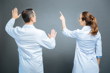 Turned back colleagues pretending to touch invisible screen