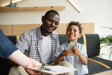 father and son paying bill - obrazy, fototapety, plakaty
