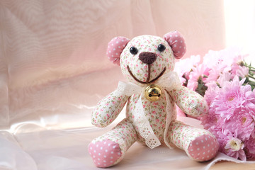Teddy Bear and dry flower on wooden background.