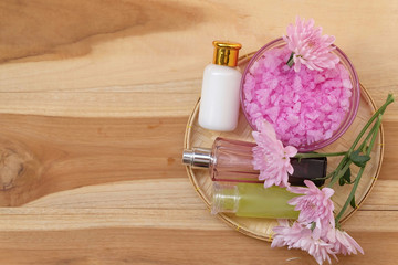 Skin cream, shampoo, salt spa and flower On a wooden background. Spa Concept.