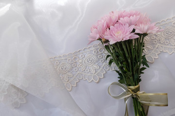 Pink flower bouquet on thin white fabric background. Wedding concept.
