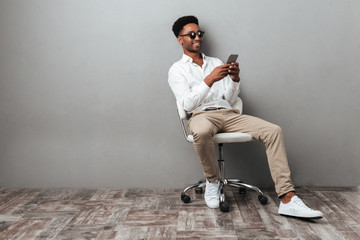 Man sitting in a chair and holding mobile phone