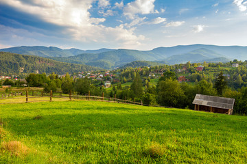 Obraz premium Summer grassland with wooden fence in Carpathian mountains countryside, Ukraine