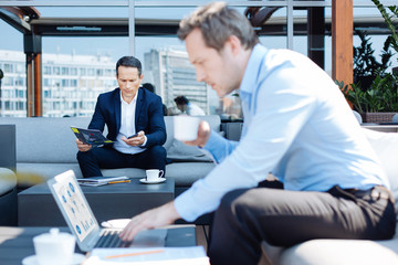 Fototapeta premium Serious nice businessman looking at his smartphone