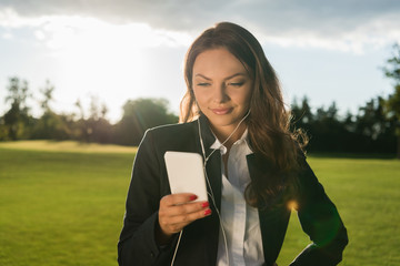 Fototapeta premium businesswoman in earphones with smartphone