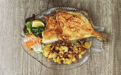 Delicious seafood dish - flounder, fried potatoes and salad