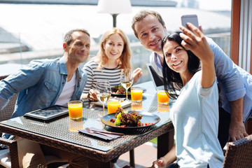Happy positive friends taking selfie