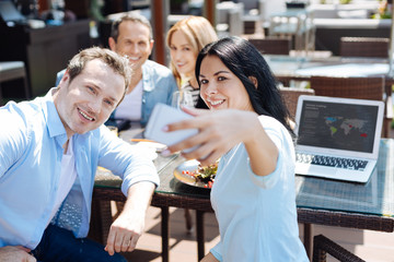 Cheerful beautiful woman holding her smartphone