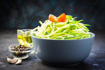 Bowl with raw spiralized zucchini noodles. Selective focus, close up.