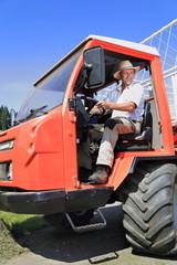 Landwirt Bergbauer Bauer in Erntemaschine Ladewagen Fahrerkabine